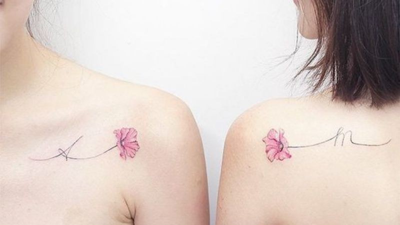 Hình xăm đôi 2 bông hoa hướng về nhau cùng chữ cái đầu của tên