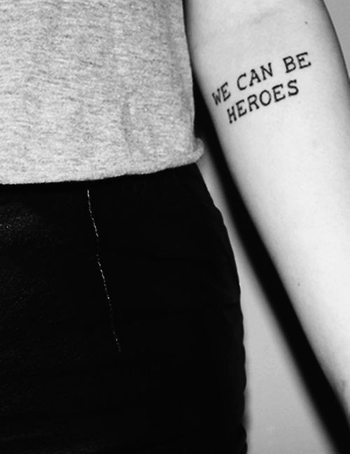 Hình xăm chữ "We can be heroes" trên cánh tay