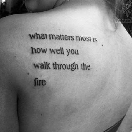 Hình xăm chữ "What matters most is how well you walk through the fire" trên cánh tay