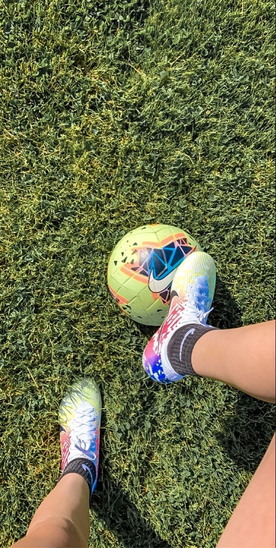 Sân bóng đá với ánh sáng tự nhiên chiếu rọi, làm nổi bật màu xanh của thảm cỏ