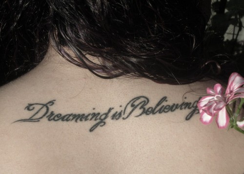 Hình xăm chữ "Dreaming is believing" trên vai