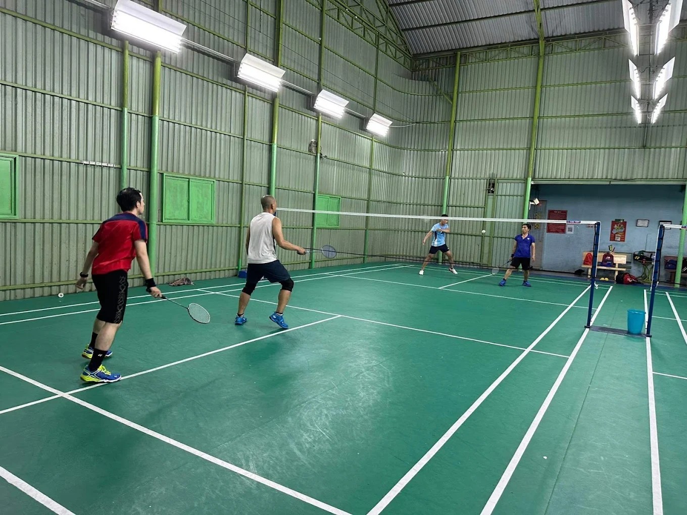 Nhân viên đang hỗ trợ khách hàng tại quầy dịch vụ tiện ích của sân cầu lông Gia Bảo