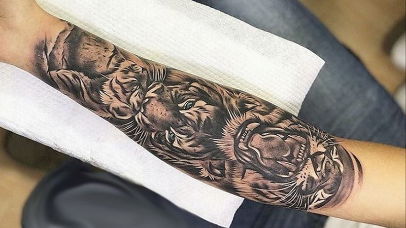 Hình xăm hổ quyền lực ở cổ tay nam, nét đen mạnh mẽ, cảm hứng bản lĩnh