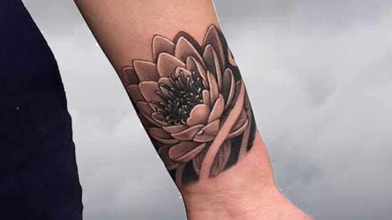 Hình xăm hoa sen mini ở cổ tay, blackwork tinh tế, biểu tượng thanh khiết