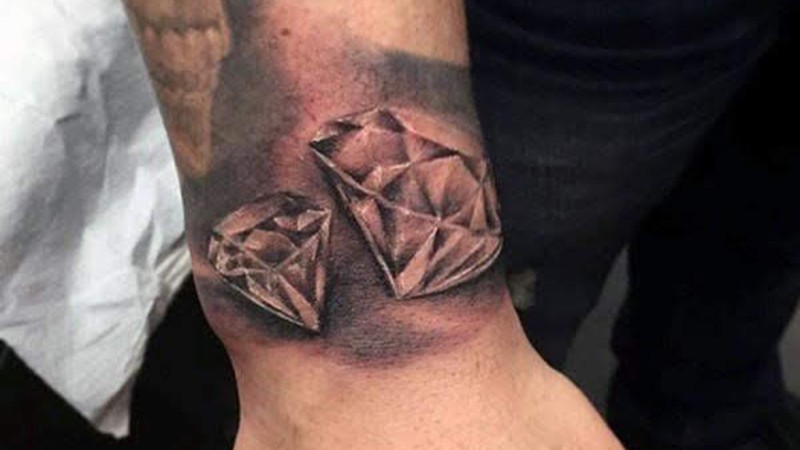 Hình xăm kim cương mini đôi ở cổ tay, blackwork sắc nét, biểu tượng bền bỉ