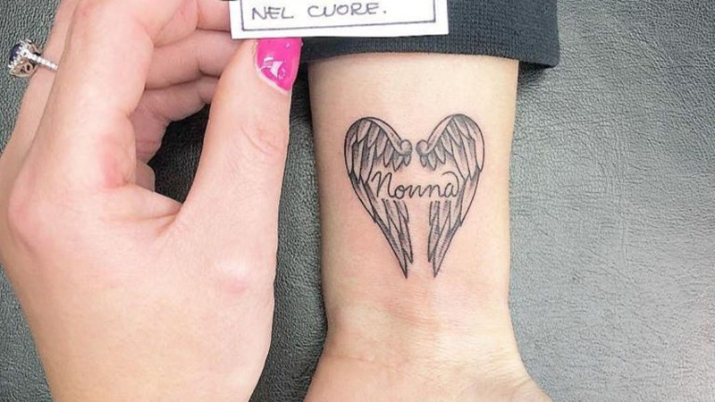 Hình xăm đôi cánh thiên thần kèm dòng chữ Nonna ở cổ tay