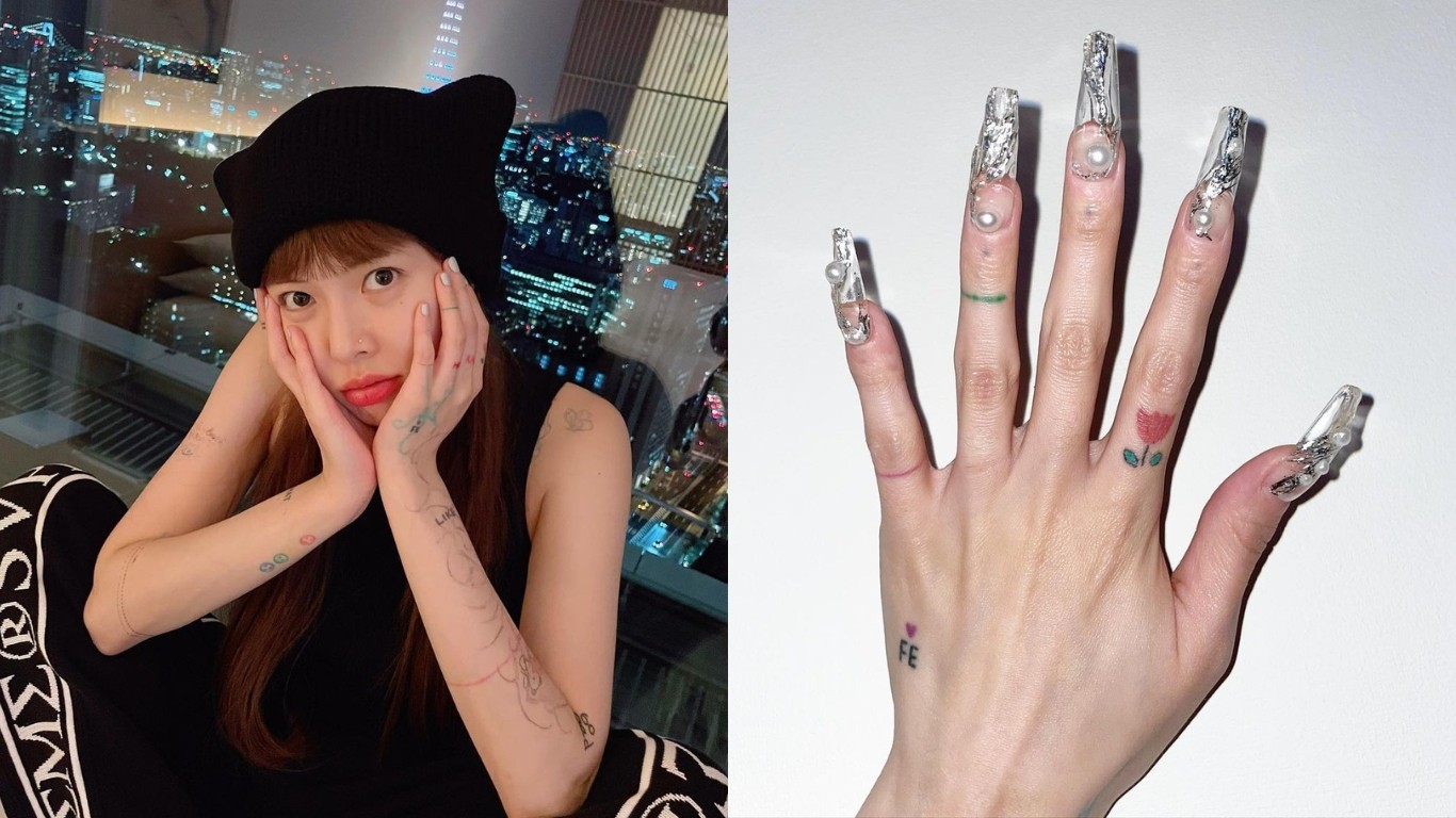 xăm hình - HuynA mặc áo tank top màu đen, đội mũ len và tạo dáng chống cằm để chụp ảnh